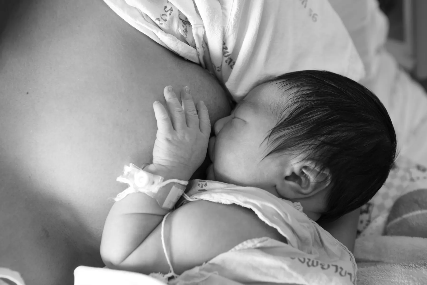 A parent holding a newborn close